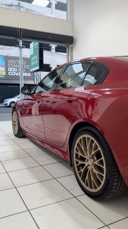 Jaguar vermelho com rodas douradas na loja