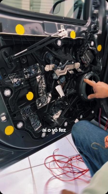 Porta de carro aberta com tratamento acústico durante instalação de alto-falante